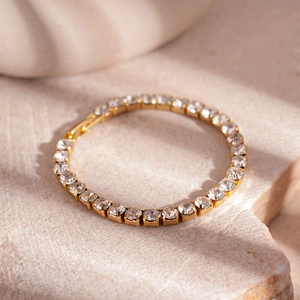 Close-up of golden tennis bracelet with round cubic zirconia in four-prong setting