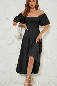 Détail de robe longue noire à épaules dénudées avec manches bouffantes et jupe à volants
