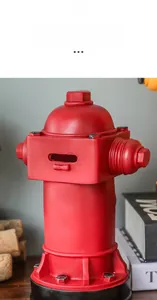 Détail de la tirelire borne d'incendie rouge rétro montrant la fente et la texture rustique