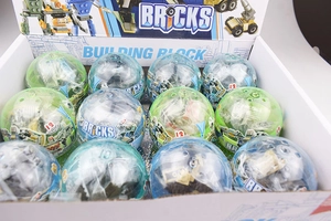 Detailed top view of 12 colorful building block gashapon toy capsules in a display box