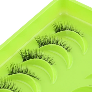 Detail of five pairs of natural black half-lashes in a bright green storage tray