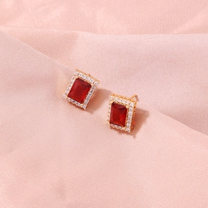 Golden clover-style stud earrings with ruby red zircon stone and white crystal border