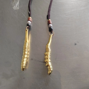 Détail macro du porte-clés cordyceps doré avec perles en bois et corde tressée