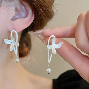French style matte white flower earrings with pearl pendant worn by model on ear