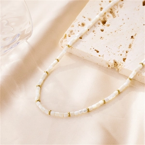 French vintage necklace with white shell beads and gold spacers on elegant satin