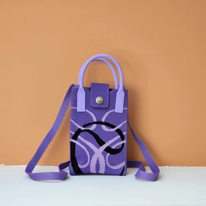Close-up of purple woven crossbody phone bag with metal magnetic clasp and curved pattern