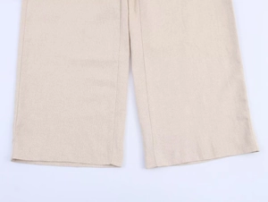 Détail du pantalon en lin beige montrant la texture du tissu et les coutures de qualité