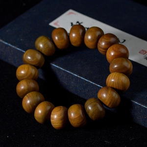 Gros plan d'un bracelet de perles en bois de santal vert montrant le grain naturel poli