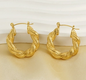 Détails macro de boucles d'oreilles créoles en U avec texture torsadée dorée 18K