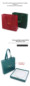 Detail of luxury peacock blue pearl jewelry box and textured gift bags with gold foil text