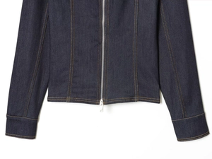 Détail d'une veste en jean indigo avec fermeture éclair argentée et coutures jaunes