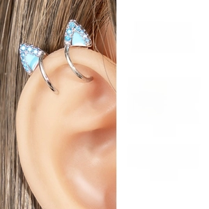 Detailed close-up of a silver cat ear cuff with blue enamel and zircon inlay on model