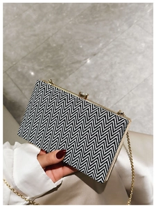 Detail of evening clutch with black and white wave pattern, gold frame and diamond clasp