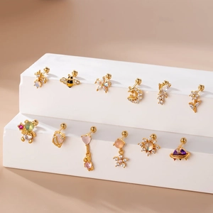 Detailed view of 12 golden stainless steel ear studs with stars and moons and zircons
