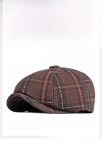 Detailed close-up of brown checkered wool newsboy hat with retro British pattern texture