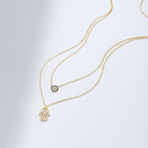 Double-layer S925 sterling silver necklace featuring gold Evil Eye and Hamsa Hand pendants