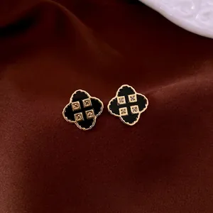 Elegant gold-plated four-leaf clover earrings with black enamel and zircon stones