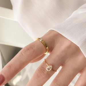 Elegant gold stacked rings with drop-shaped and rectangular crystals on white background