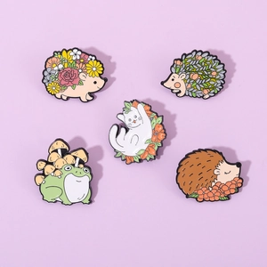 Cartoon animal enamel pins set featuring hedgehog, cat, and frog with floral elements