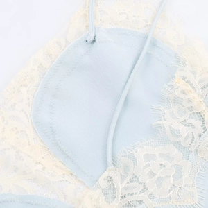 Detail of light blue lace lingerie top showing delicate patterns and zigzag stitching