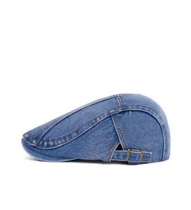 Side view of vintage washed denim beret featuring orange topstitching and metal buckle