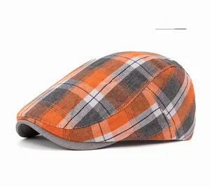 Close-up of orange plaid fabric texture and reinforced brim of a vintage flat cap