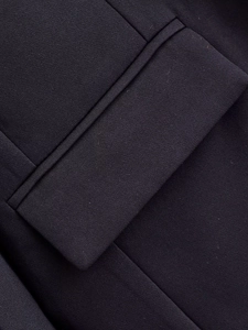 Detailed close-up of a classic blazer flap pocket with precise stitching and woven texture