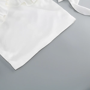 Detailed close-up of white ruffled hemline featuring elegant pleated fabric texture