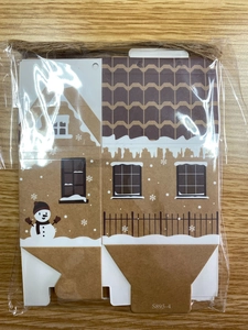 Flat-lay detail of unassembled gingerbread house gift box with twine and festive snowman prints