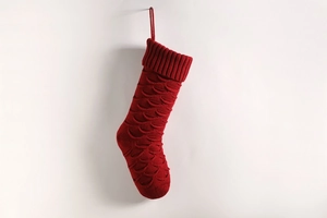 Detailed view of red knitted Christmas stocking with textured fish scale pattern
