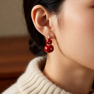 Detail view of 18k gold plated red calabash earrings on model for an elegant Chinese style