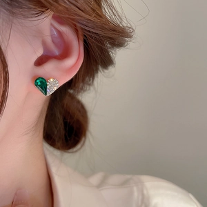 Detailed view of gold heart stud earring with green crystal and white cubic zirconia