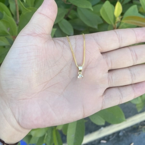 Close-up of 18K gold plated copper cross pendant with cubic zirconia on box chain