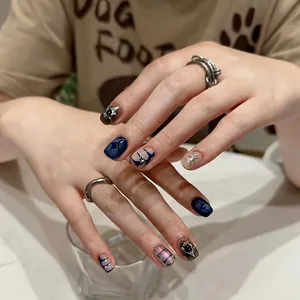 Handmade press-on nails featuring dark blue cat eye, silver stars, and metal accents