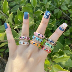 Colorful enamel copper open rings with zircon stones shown on a hand in nature