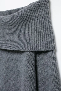 Détail d'un haut en tricot gris foncé à épaules dénudées avec col large et texture côtelée