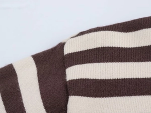 Macro detail of the shoulder seam on a brown and beige striped knit sweater