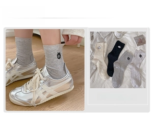 Detail of knit mid-calf socks with cute embroidered cat and dog animal faces