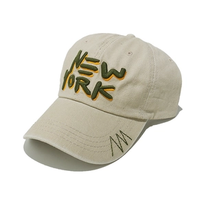 Close-up of NEW YORK 3D embroidery and stitching details on a vintage beige baseball cap