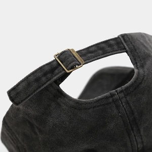 Detail of adjustable brass metal buckle and washed denim fabric on retro baseball cap