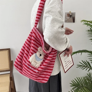 Detail of pink and red striped plush tote bag with cute bear embroidery and text