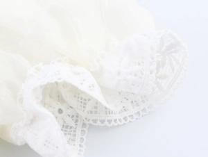 Close-up of white puff sleeve cuff with delicate wide lace trim and pleated fabric texture