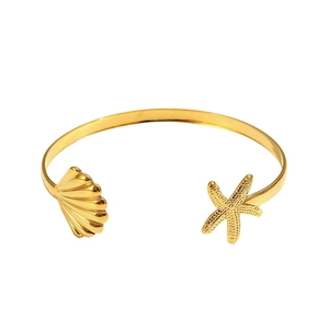 Gold ocean style open cuff bracelet with starfish and seashell charms on white background