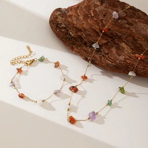 Detail of bohemian necklace with multi-color natural stones and gold metal chain