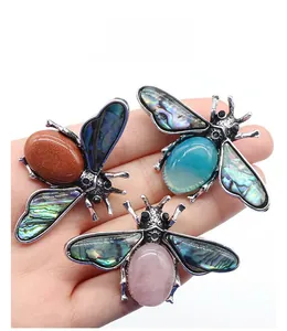 Macro detail of bee brooches with abalone shell wings and inlaid semi-precious stones