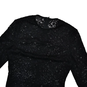 Détail d'une robe en dentelle noire avec fermeture éclair invisible et texture fine