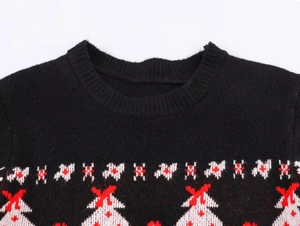 Détail de l'encolure en tricot montrant un motif jacquard d'hiver rouge et blanc sur noir