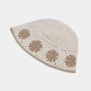 Close-up of crochet hollow flower bucket hat with beige texture and brown floral patterns