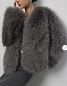 Détail d'un manteau court en fausse fourrure grise avec une texture dense et des poils longs