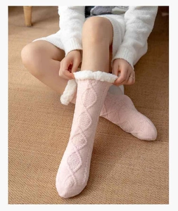Detail of pink cable knit winter floor socks with cozy white faux fur trim and soft texture